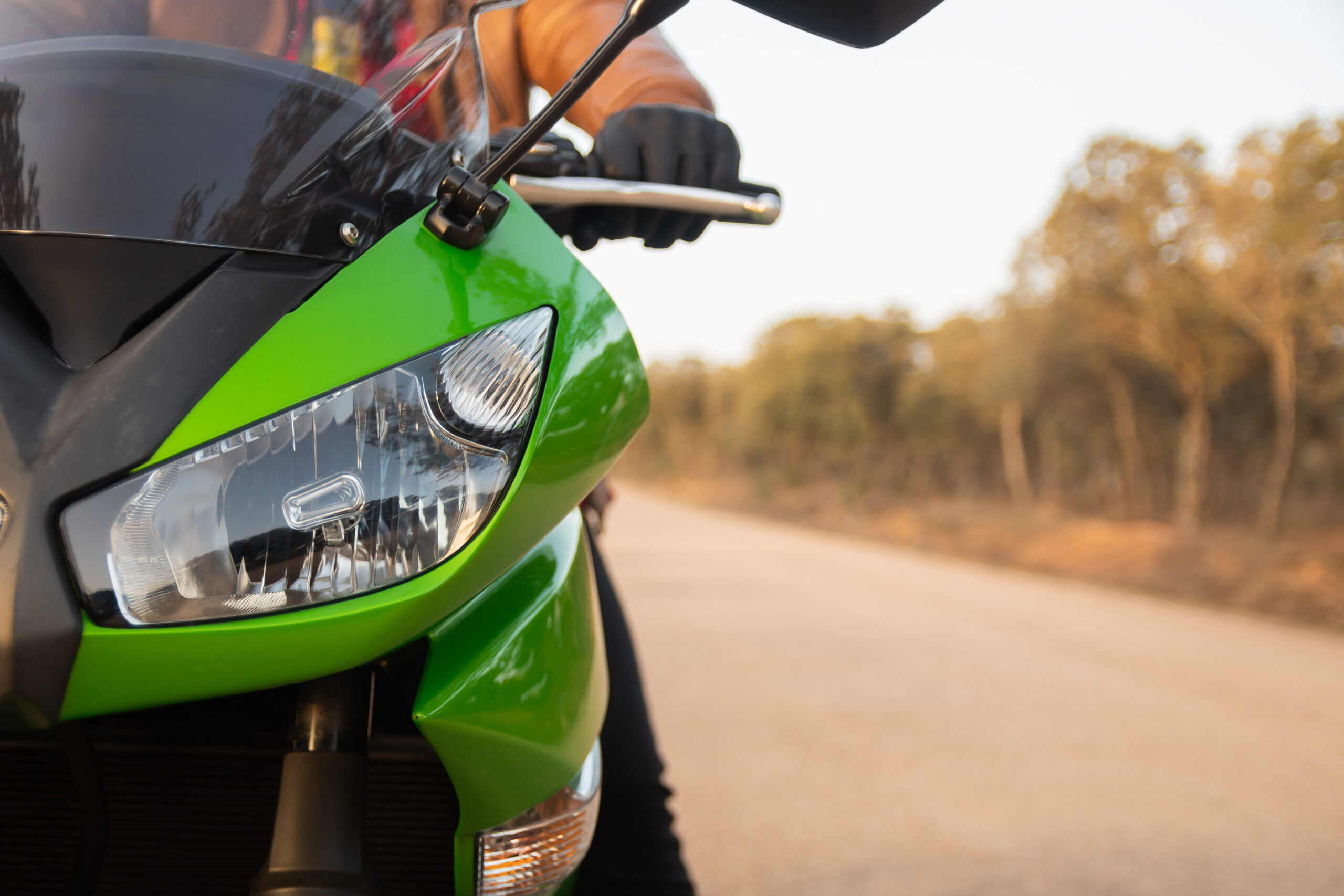 grünes Motorrad mit Wald im Hintergrund